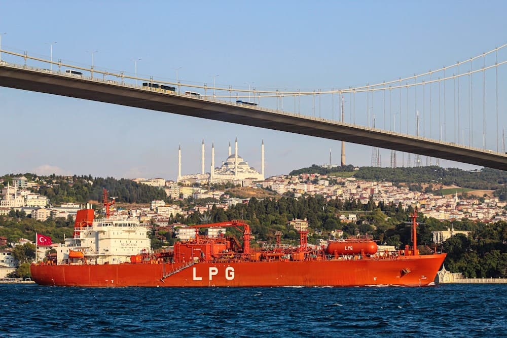 LPG gas carrier transiting a strait beneath a suspension bridge